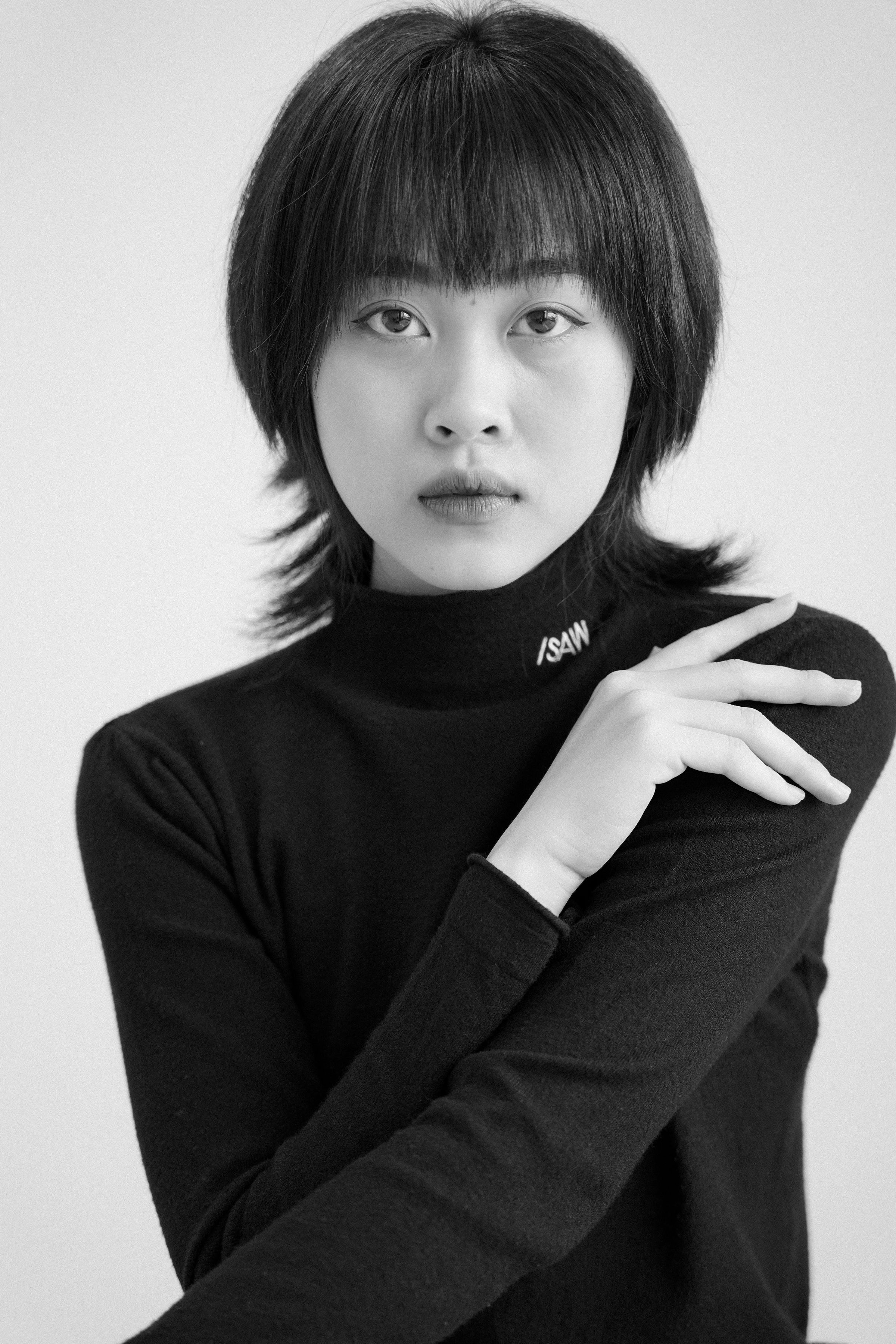 Black-and-white studio portrait of a woman in a black turtleneck