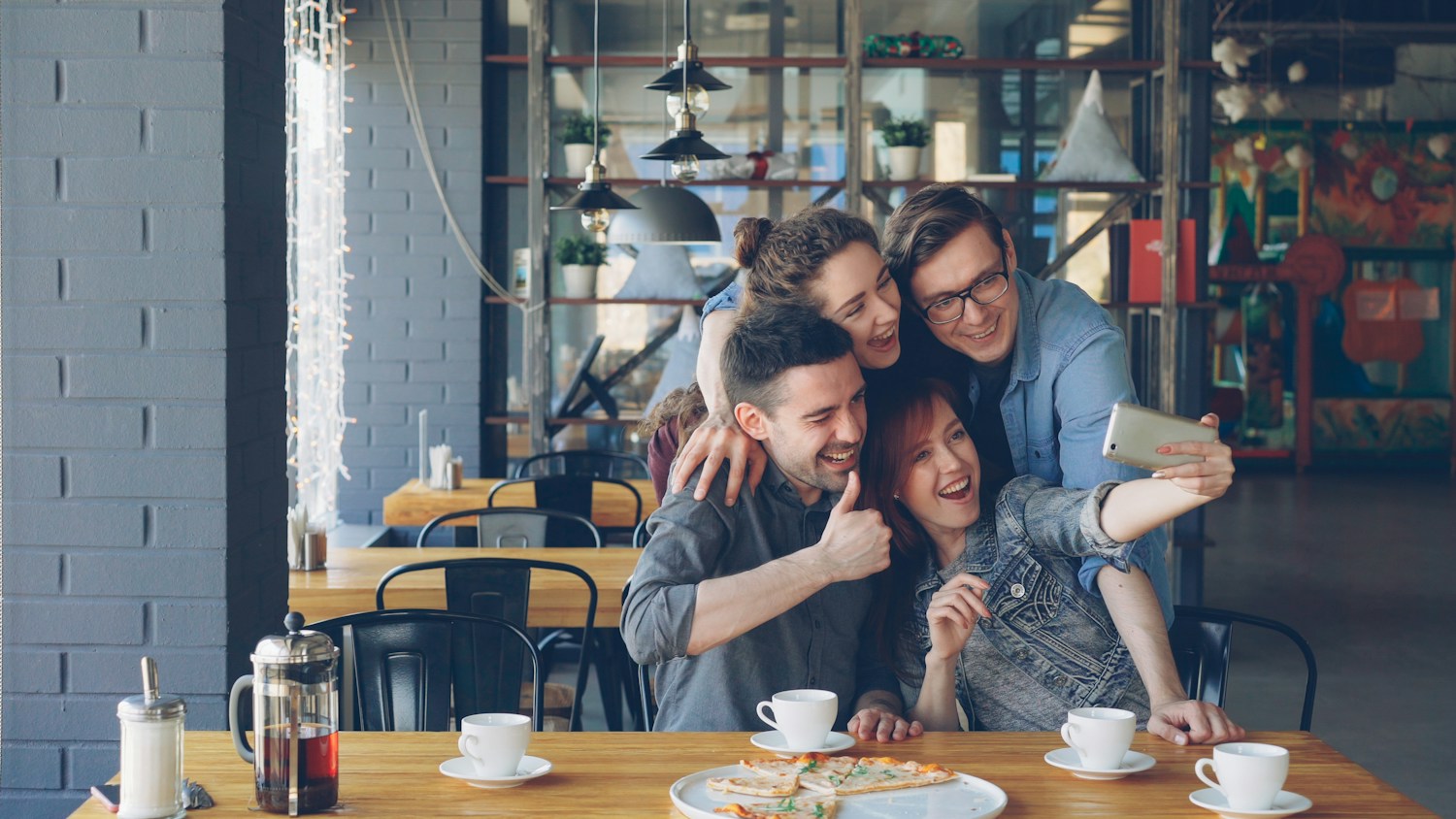 Friends laughing and sharing a candid moment at a cafe