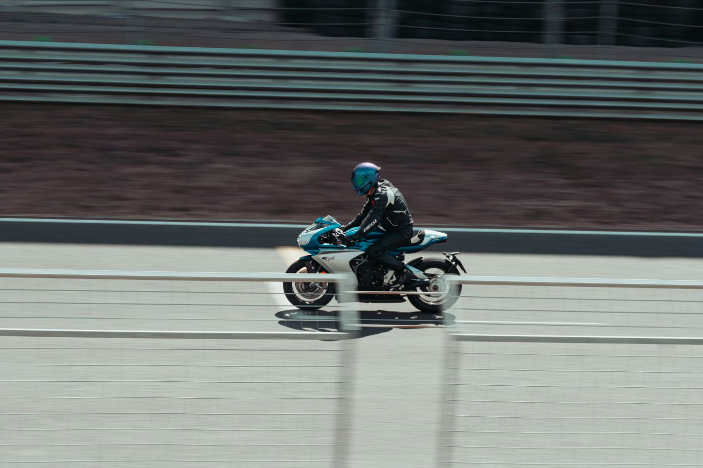 A motorcycle rider in motion against a blurred racing circuit